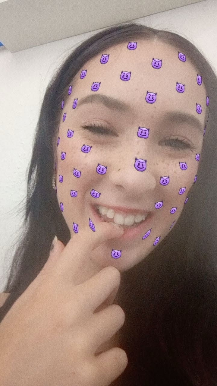 Lachende foto van haar met paarse gezichtsstickers